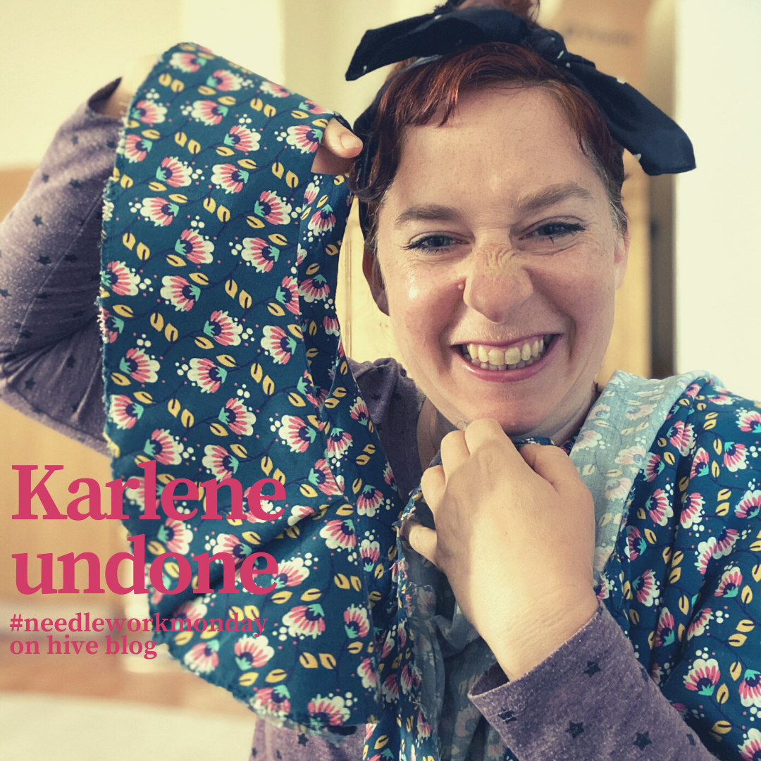 Simone, smiling widely, holding up the yoke of her Karlene blouse