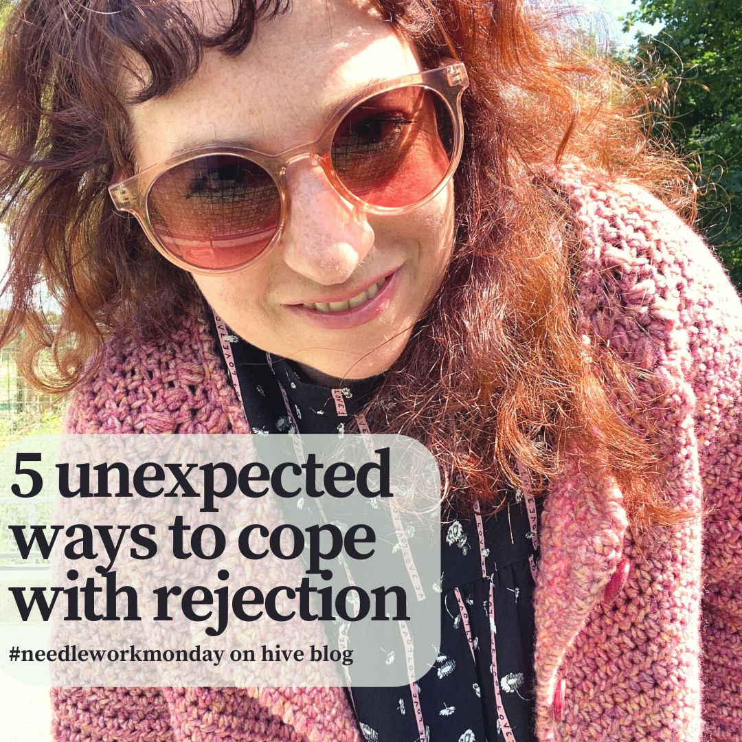 a smiling womn with curly read hair and sunglasses